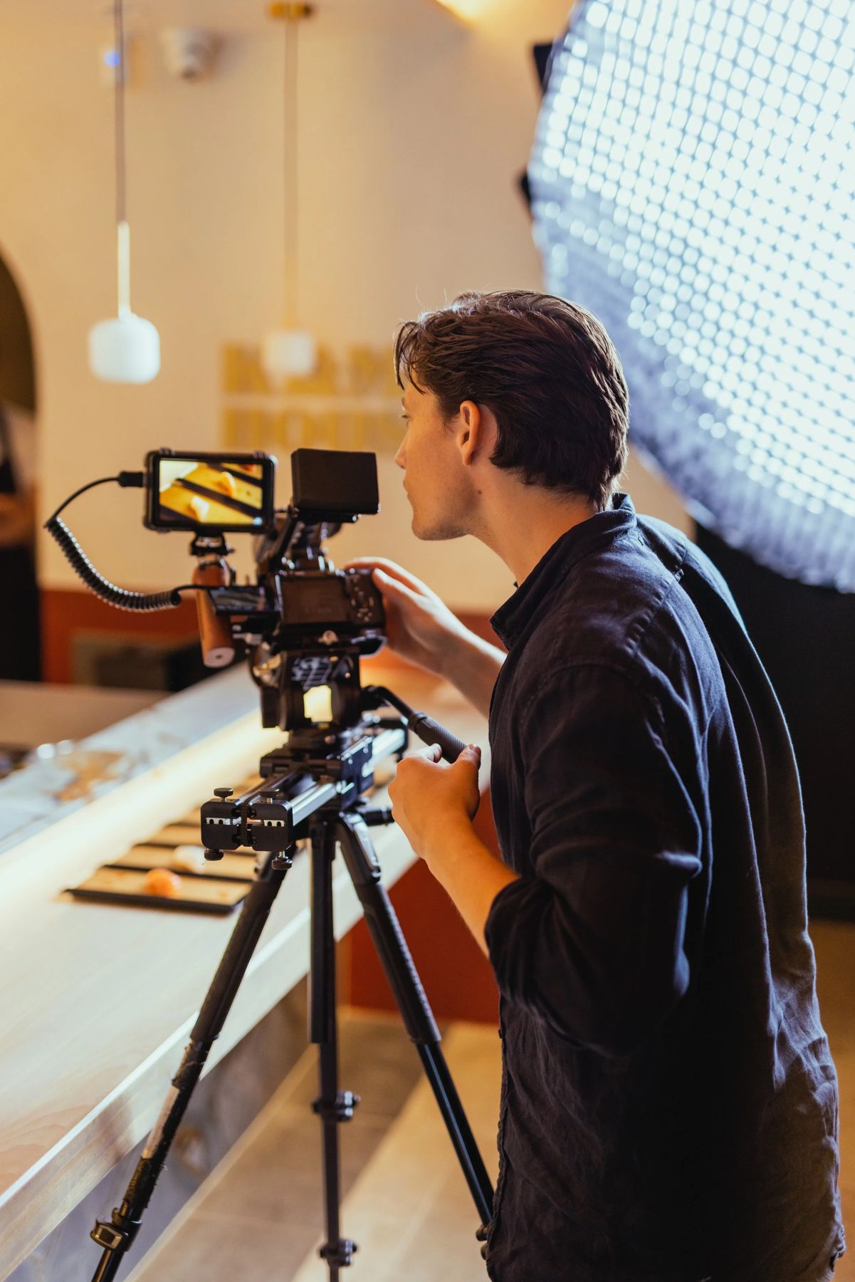 Tom Anlezark filming at a restaurant counter