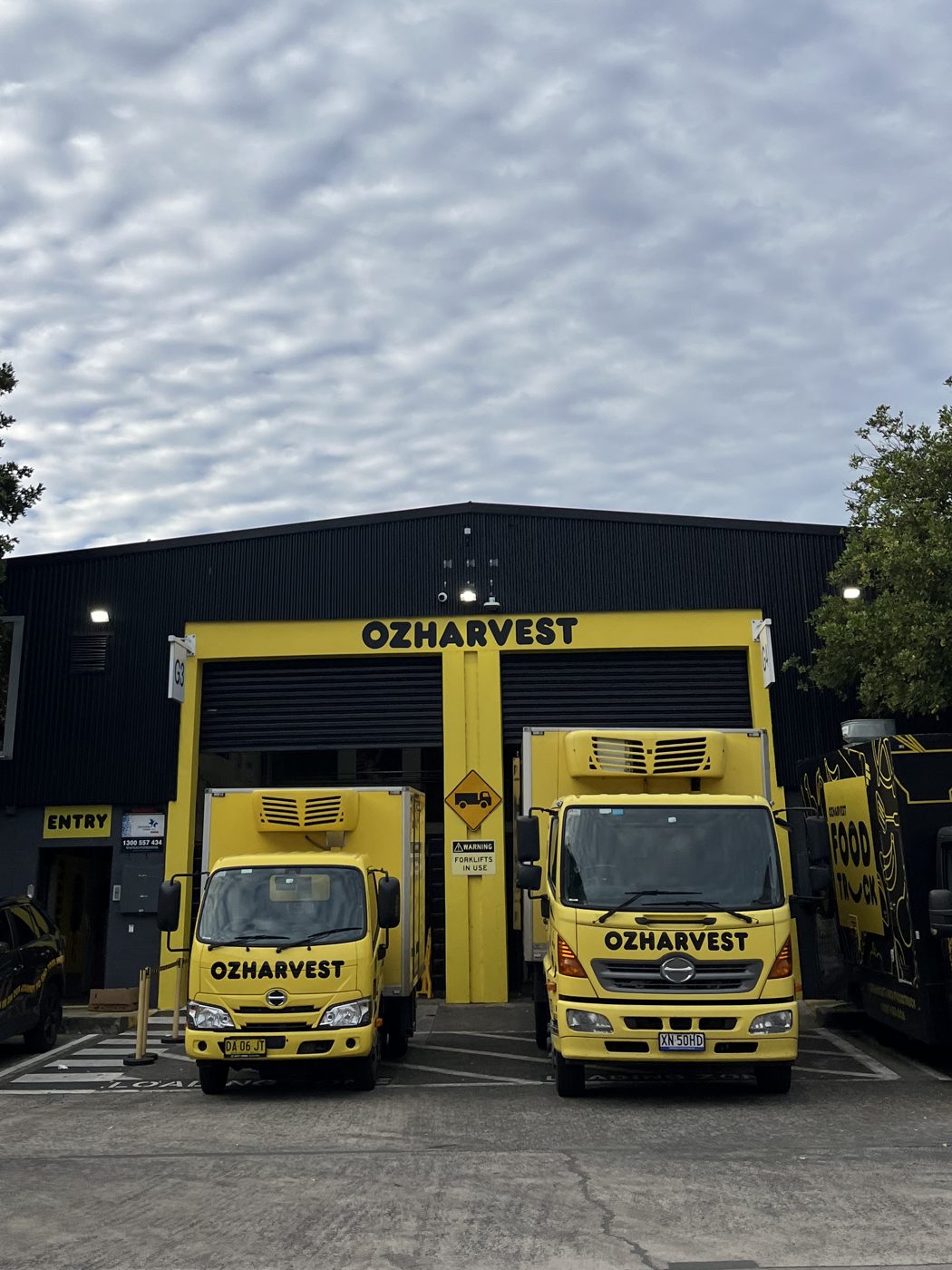 OzHarvest’s yellow trucks lined up outside their warehouse