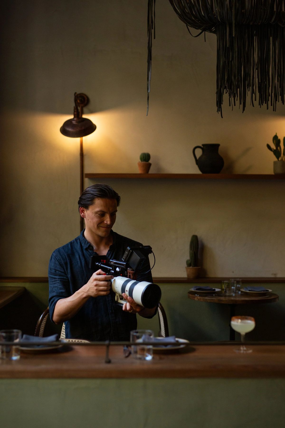 Tom Anlezark filming with a cinema camera inside a Sydney restaurant