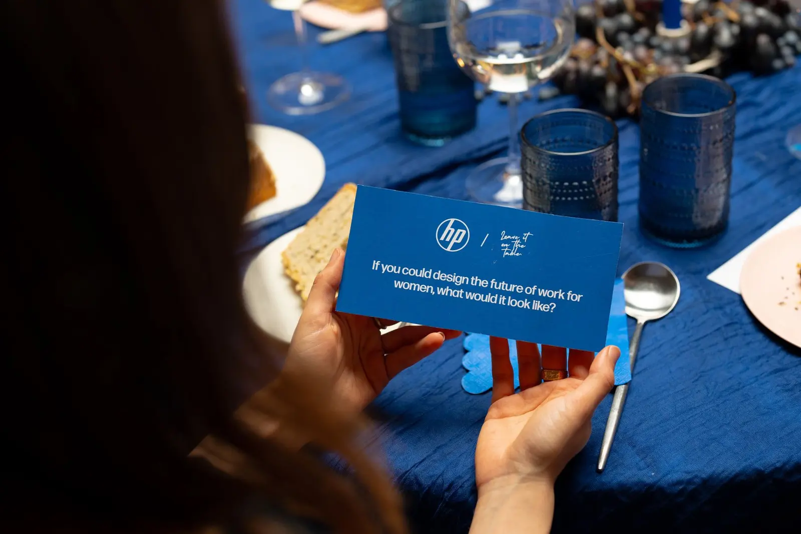 A guest reading a blue HP question card at the table.